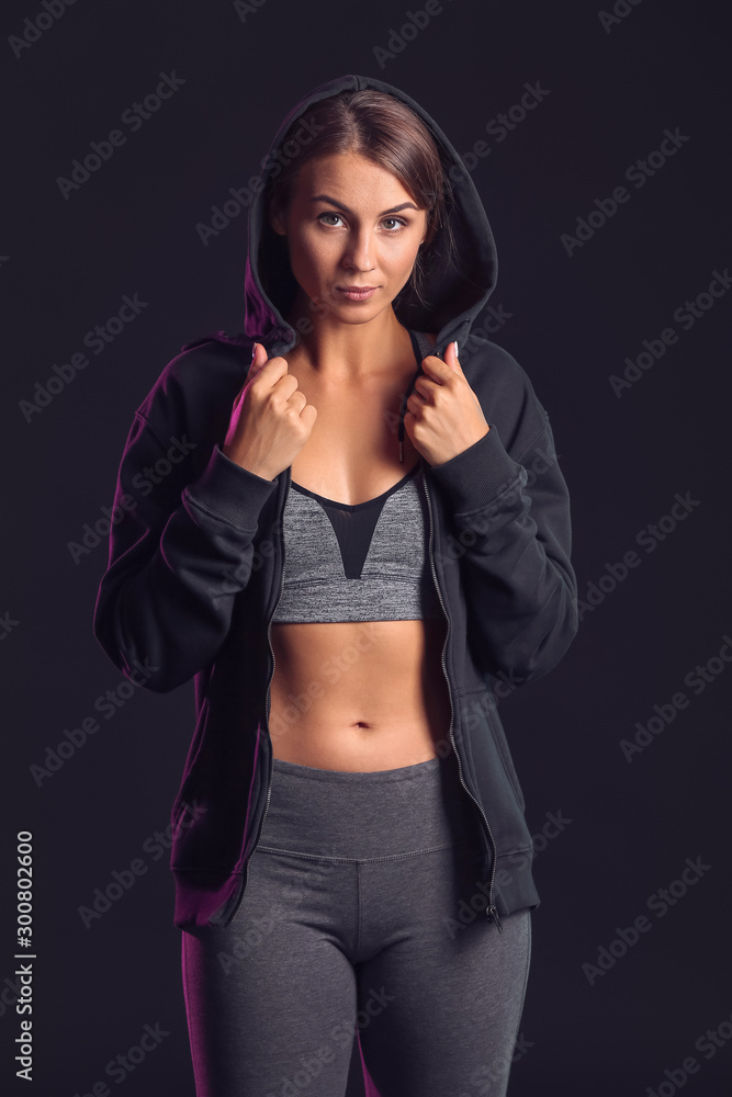 Sporty young woman on dark background