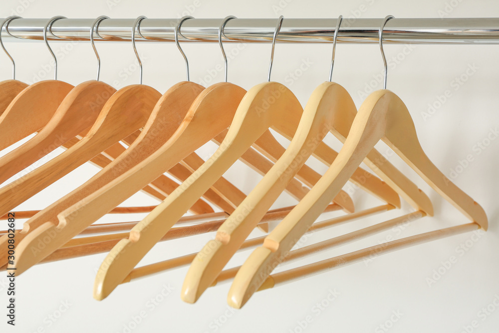 Rack with clothes hangers on white background, closeup