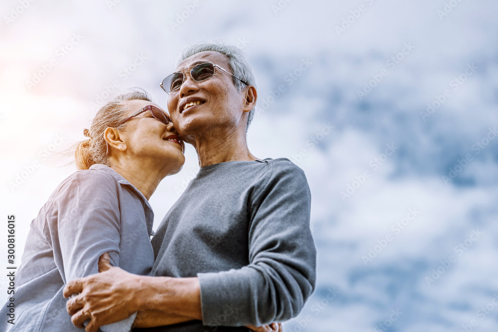 亚洲老年夫妇或老年人周末度假时在海滩散步和坐着