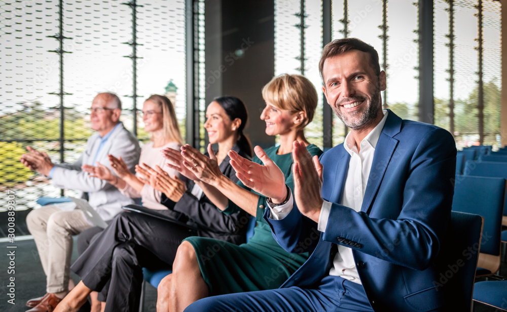 Happy audience applauding speaker at business conference