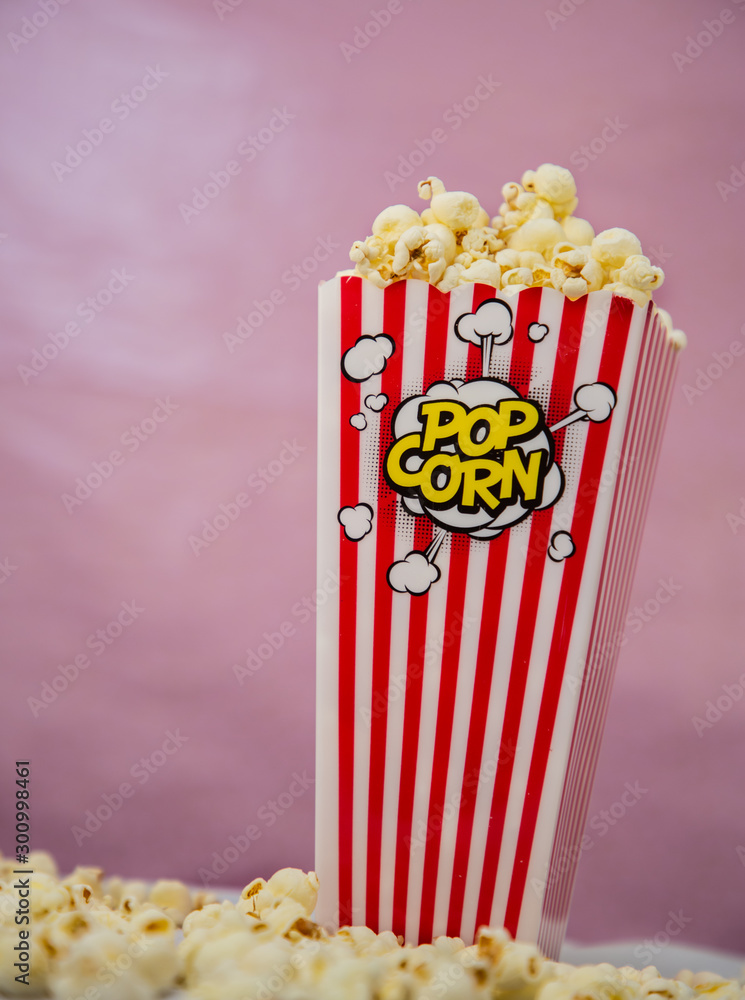 Buttered movie popcorn in a popcorn cup on white background