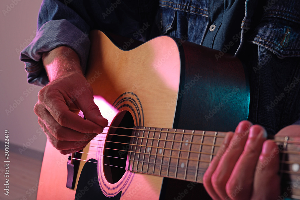 Handsome man playing guitar, closeup