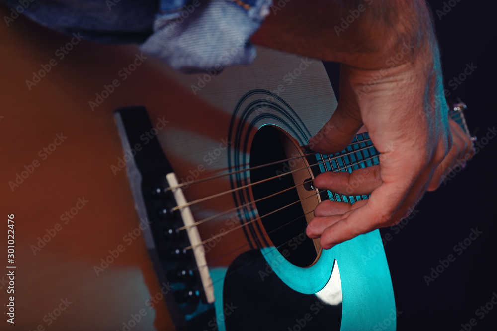 Handsome man playing guitar, closeup