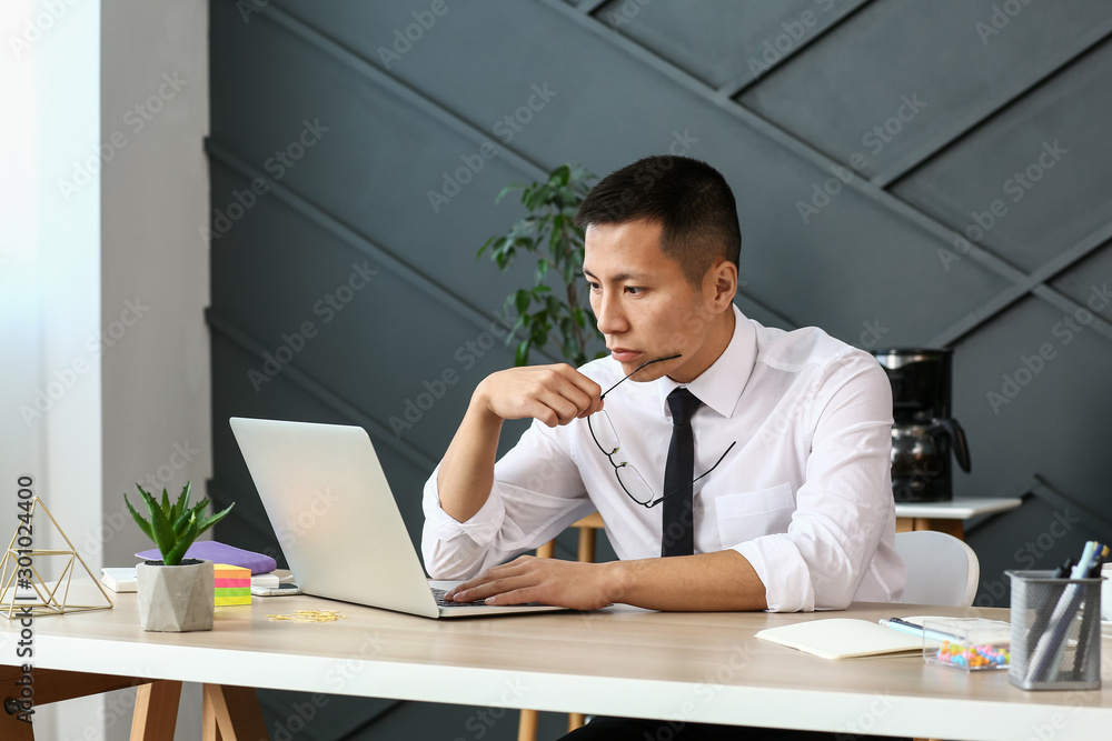 Asian businessman working on laptop in office