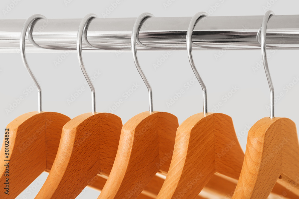 Rack with clothes hangers on white background, closeup