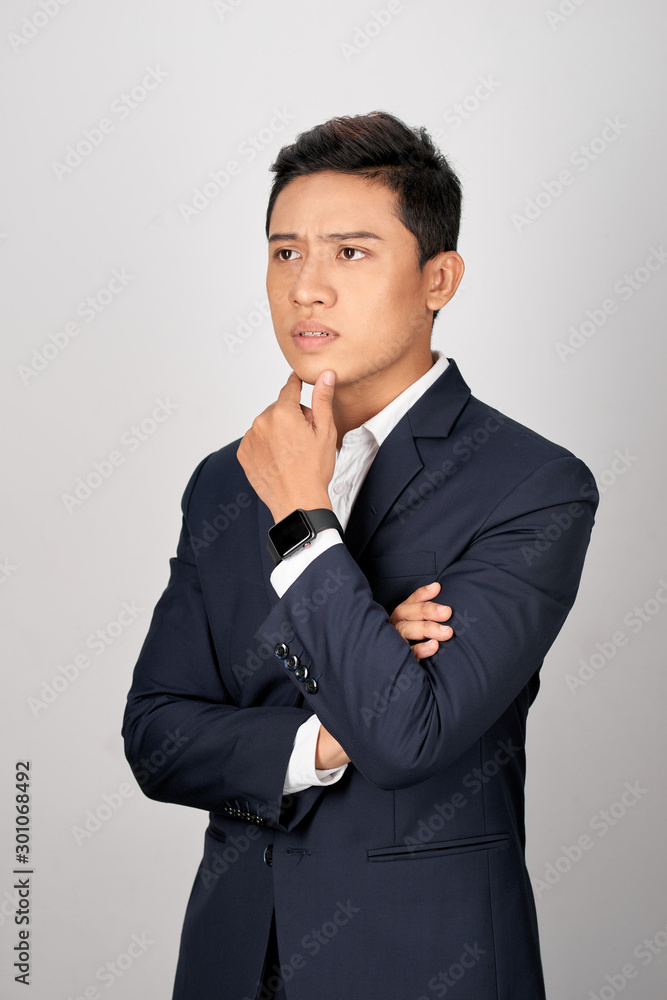 Portrait of attractive young asian businessman is confusing over white background