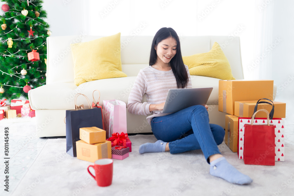 attractive asian female shopping with online market in Christmas celebration seasonal, she sitting o