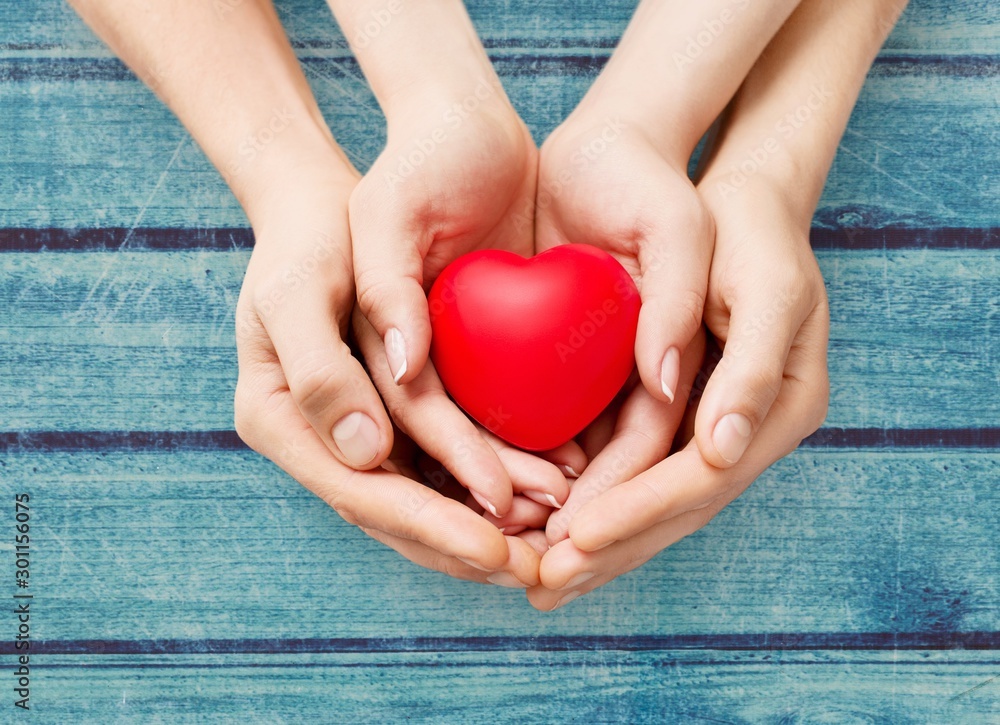 Man and woman holding red heart in hands isolated on white