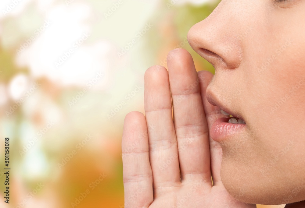 Girl listening with her hand on an ear cose up