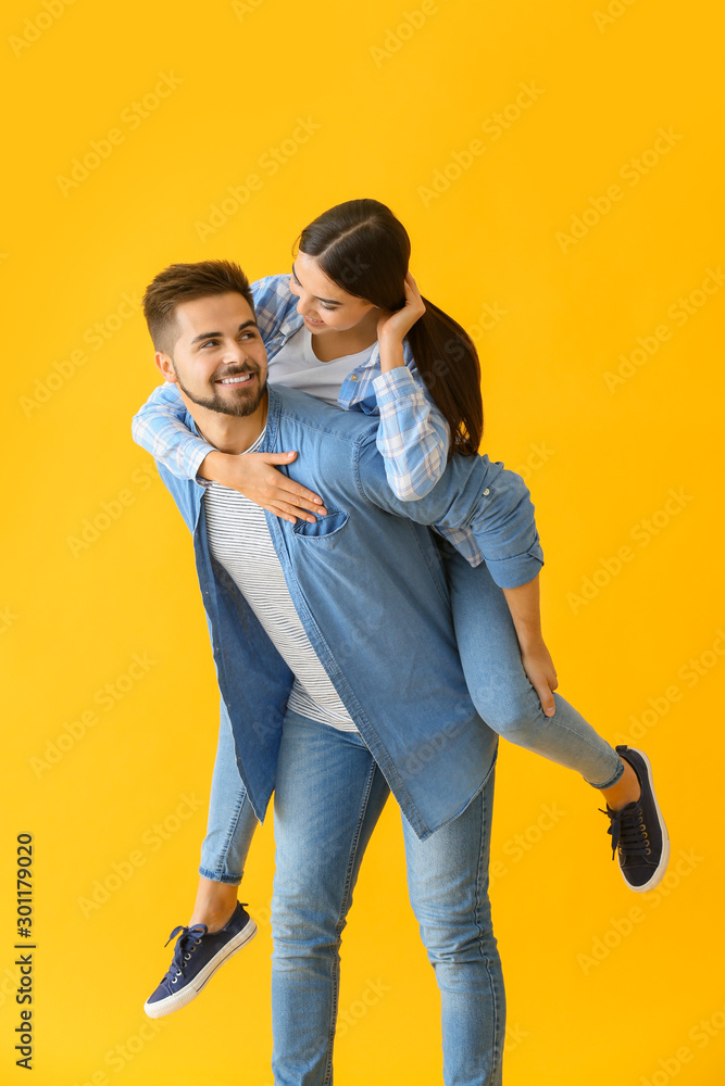 Portrait of happy young couple on color background