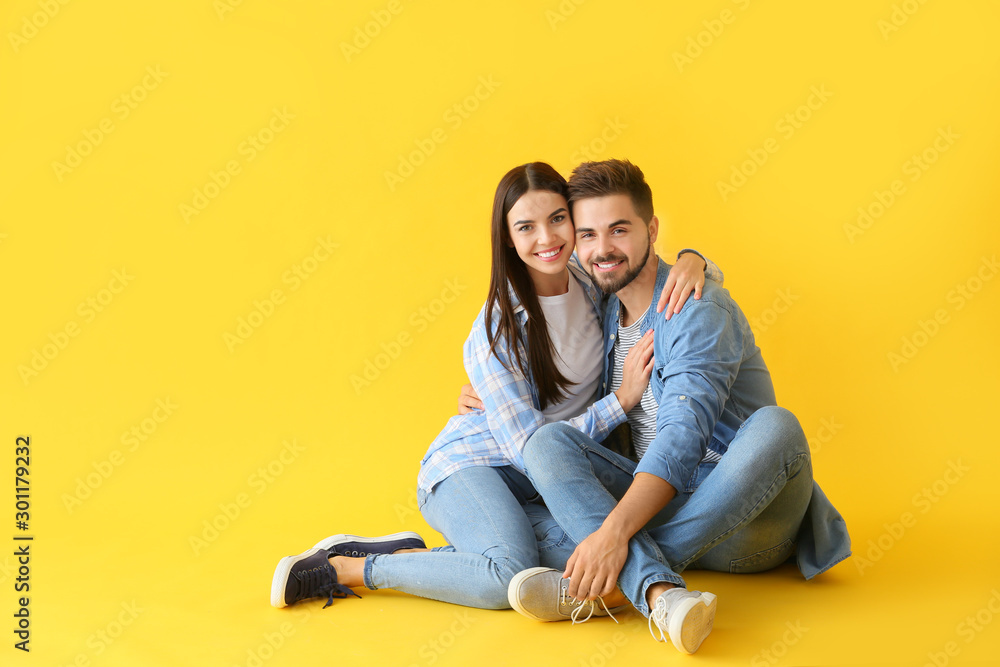 Portrait of beautiful young couple on color background