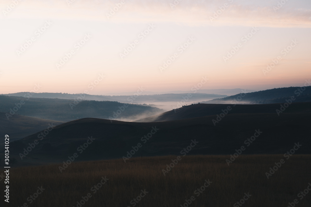 In the morning at sunrise and fog at the foot of the mountains