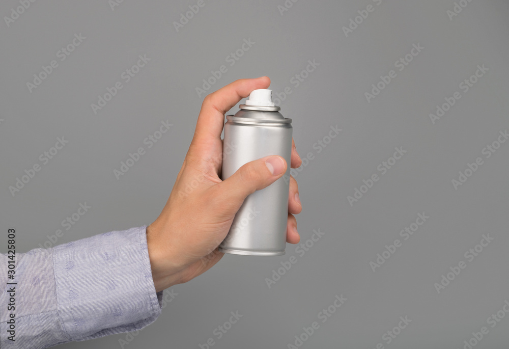 hand holds aerosol spray can