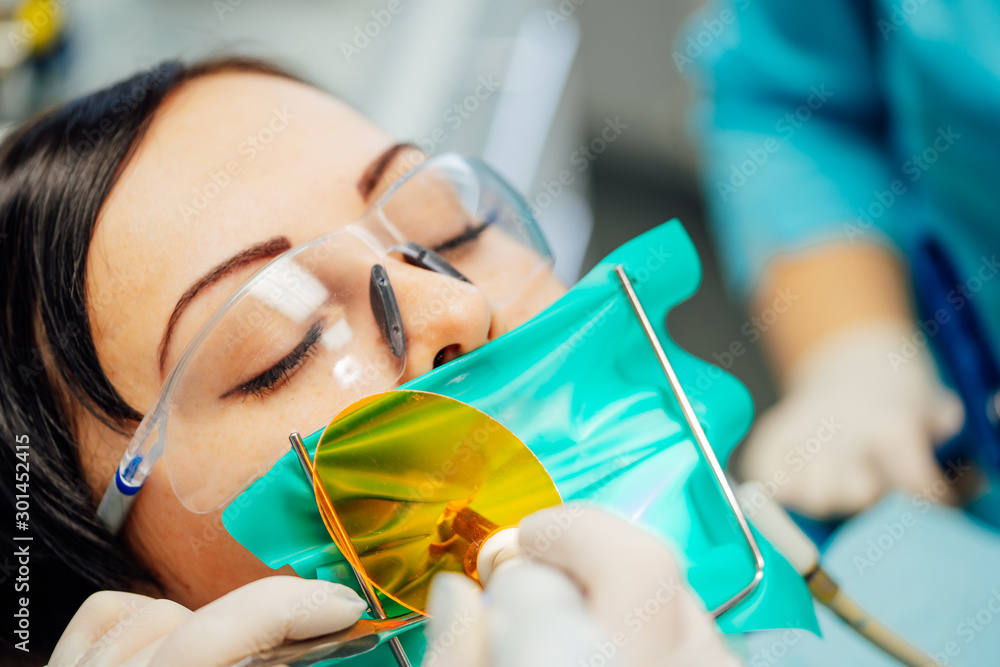 Beautiful woman patient having dental treatment at dentists office. Female visiting stomatology. Or