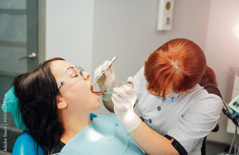 Female dentist is working in modern stomatology clinic. Stomatological instrument in the dentist cli