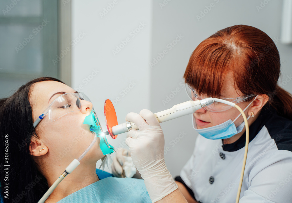 Female dentist is working in modern stomatology clinic. Stomatological instrument in the dentist cli