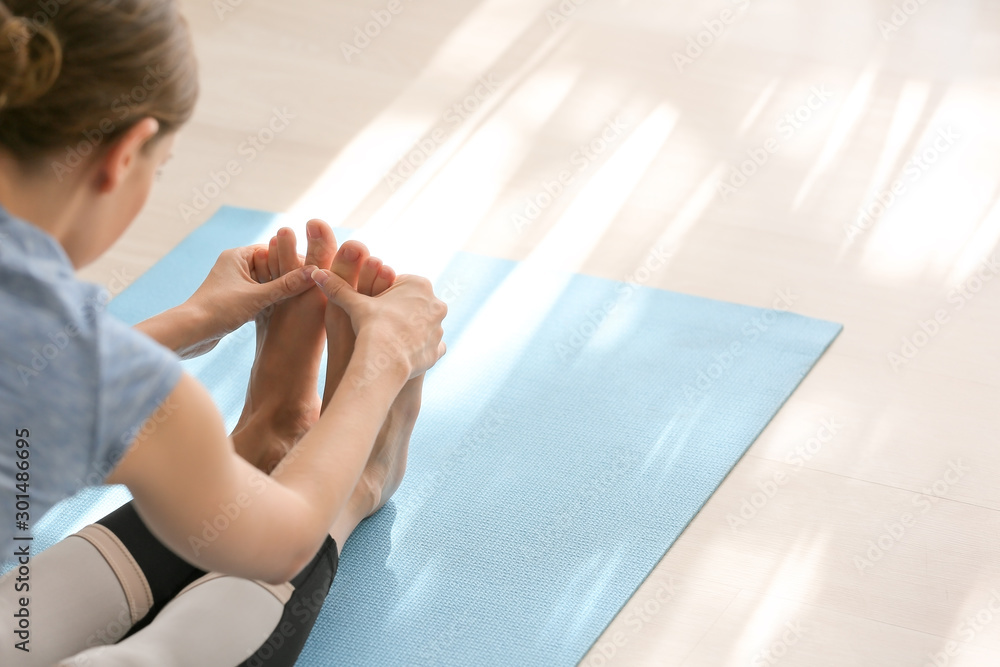 Young woman practicing yoga at home