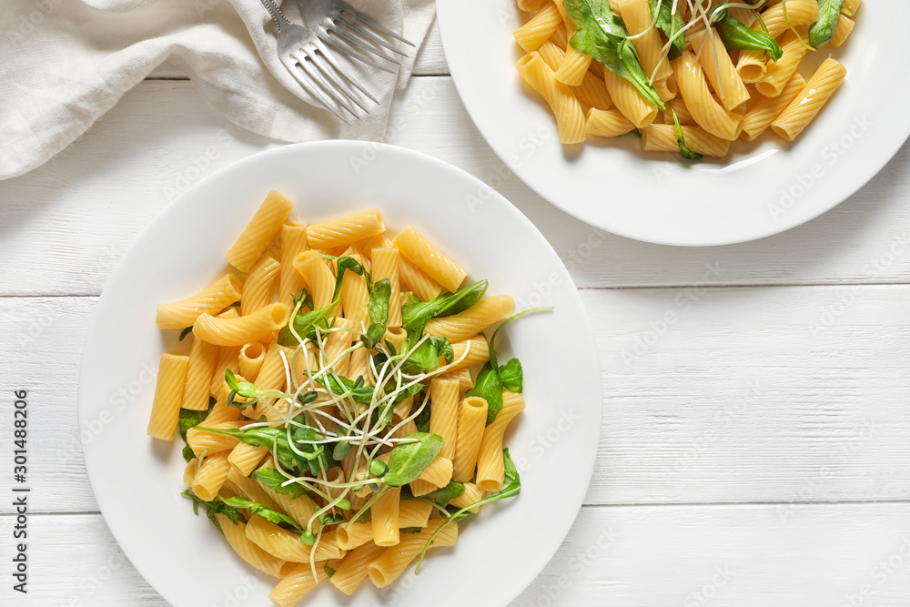 Plates with tasty pasta on table