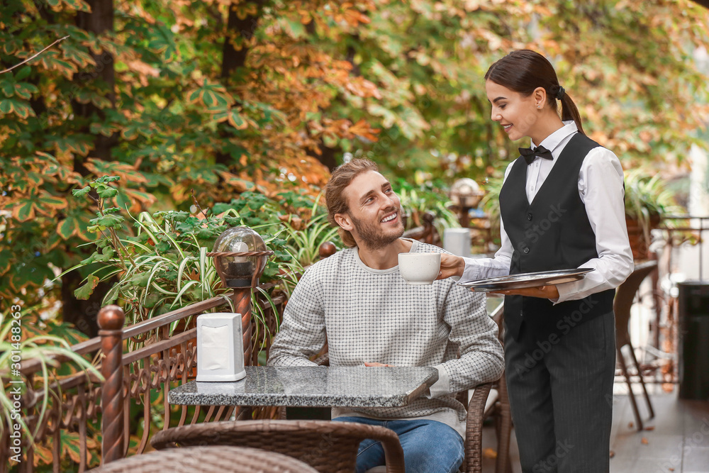 Waitress serving client in restaurant