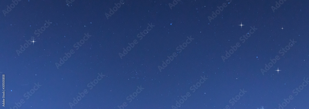 全景蓝色夜空，银河系和黑暗背景下的恒星。宇宙充满了恒星、星云和