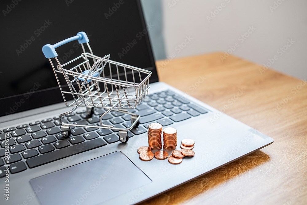 Laptop and online shopping cart on the desk, shopping cart background material