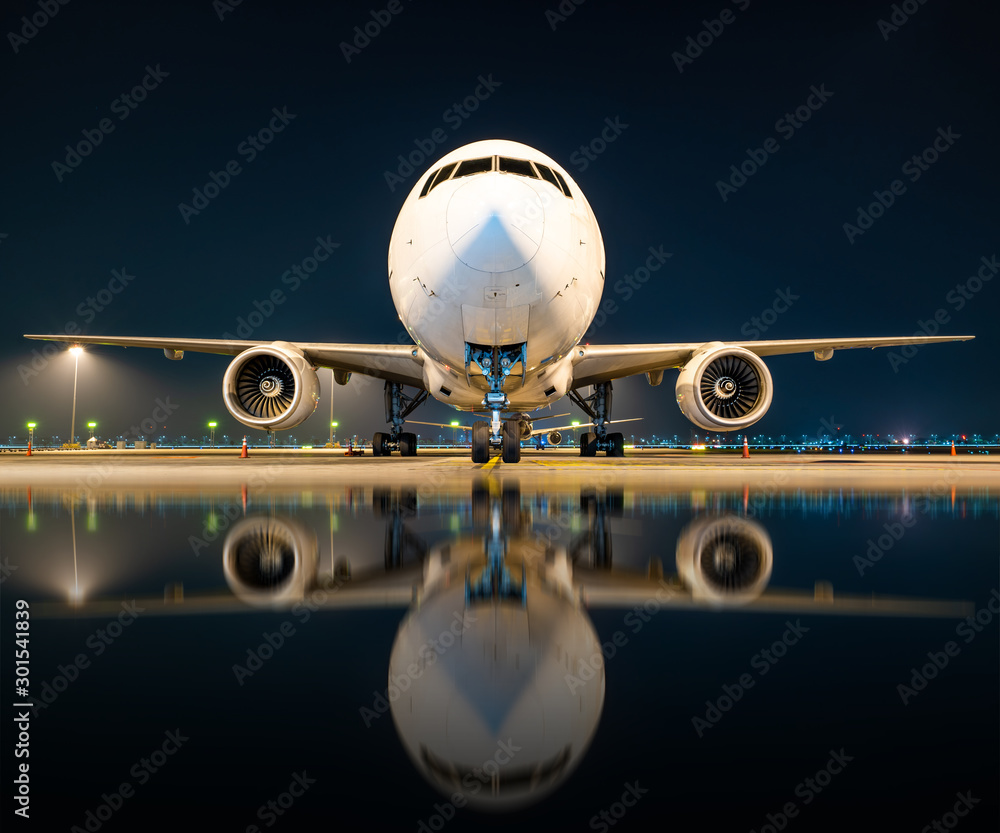 aircraft parking at gate in night with reflection