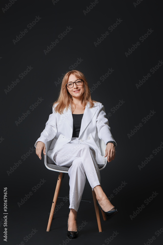 Stylish mature businesswoman on dark background