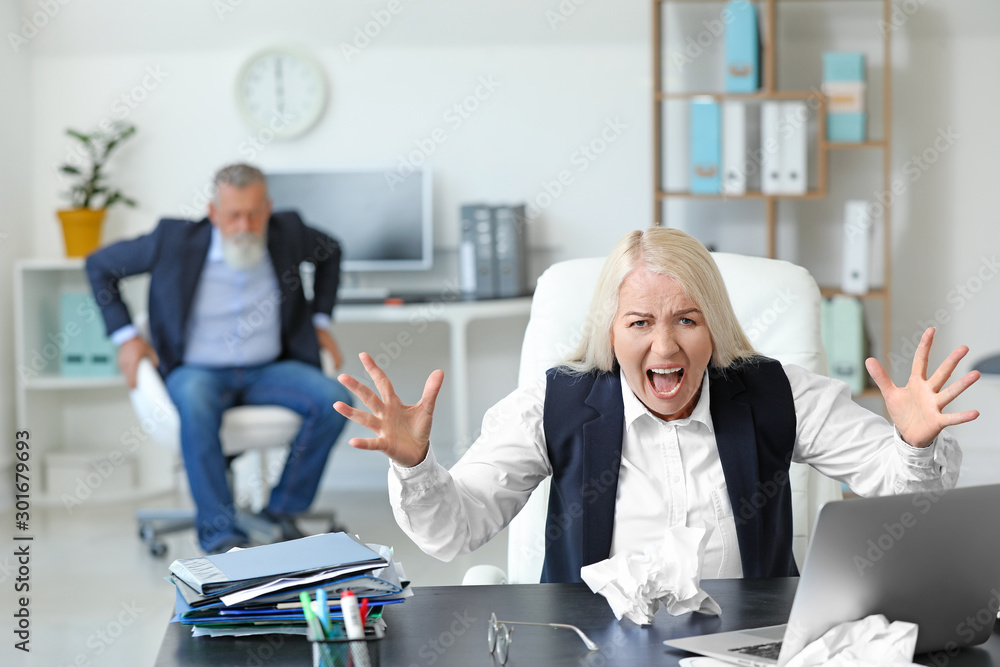 Angry mature woman working in office