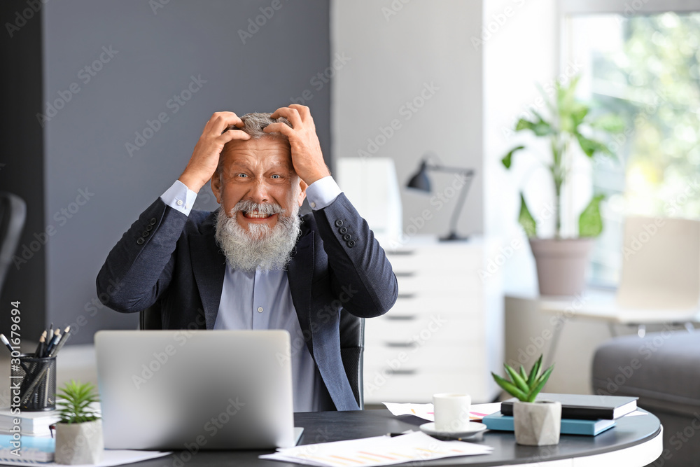 Angry mature man working in office