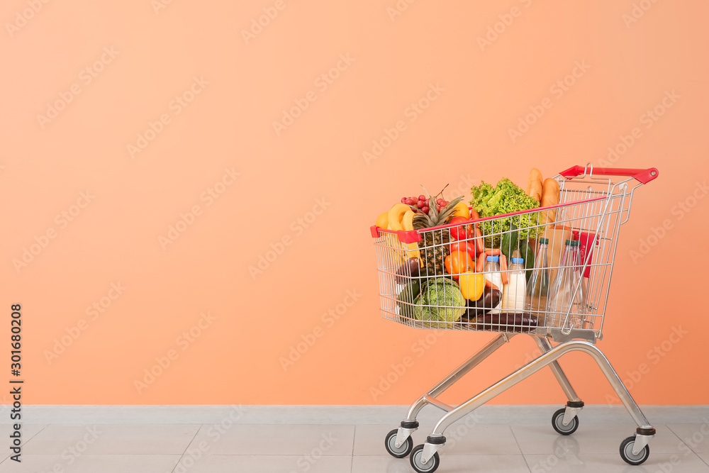 Shopping cart with products near color wall