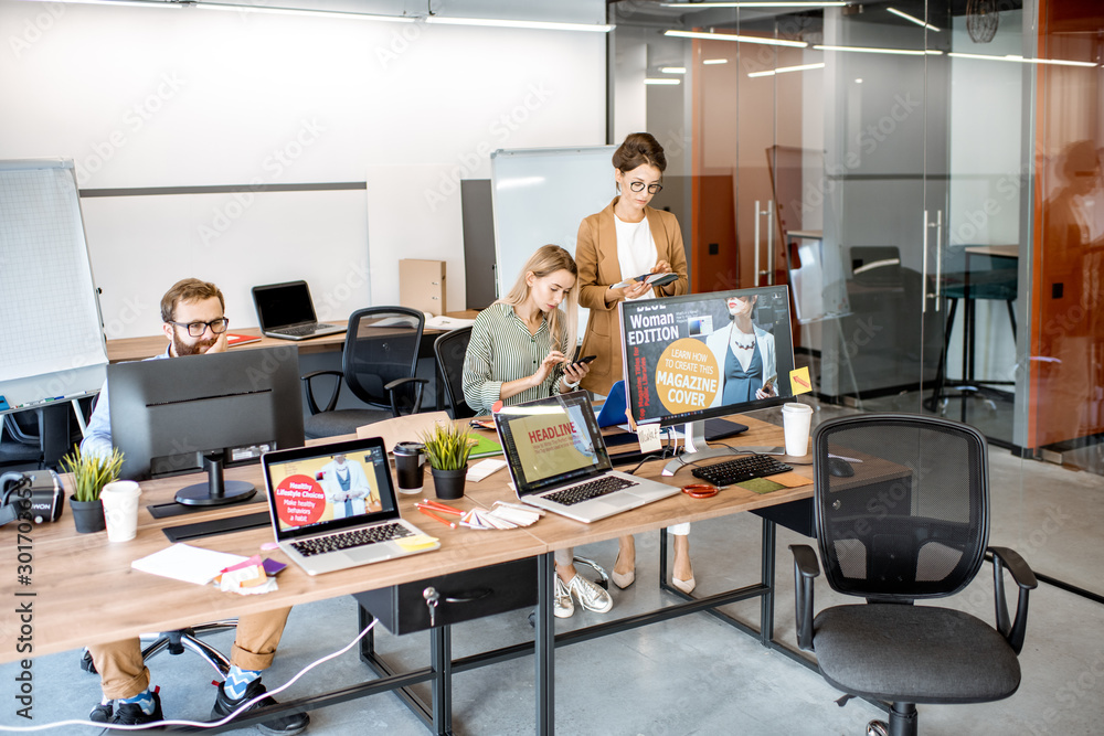 Modern office room of web designers with working places and people working