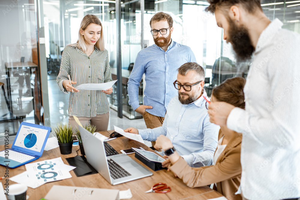 Group of diverse colleagues working in the office, having discussion or small conference on a workin