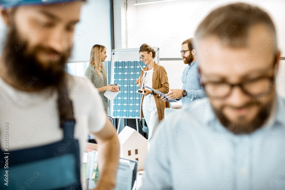 Group of people working on a project of alternative energy in the office, foreman and builder on the