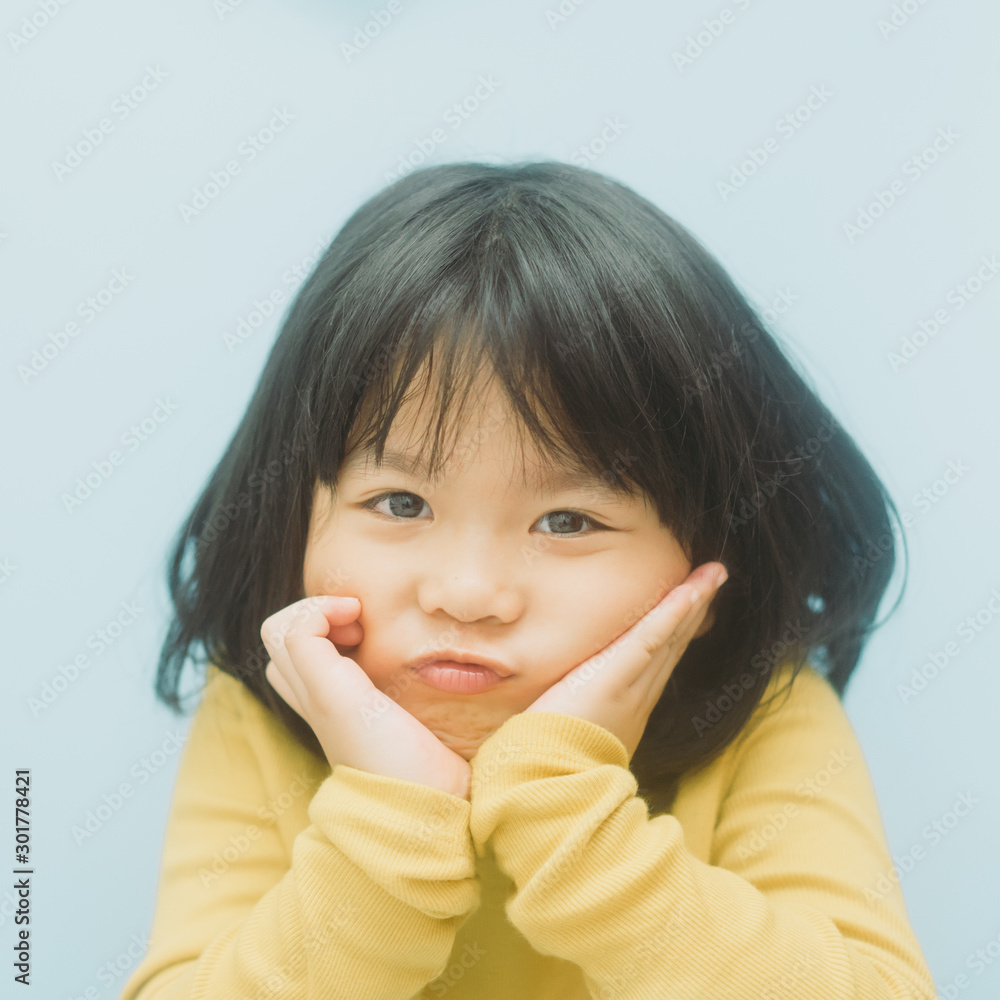 Portrait of young cute little asian girl in winter.4 years old little girl with yellow shirt and loo