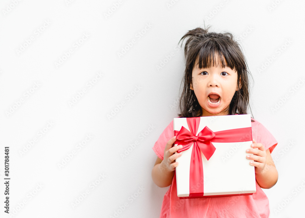 Little asian girl smile and excited and holding red gift box on white background.child holding gift 