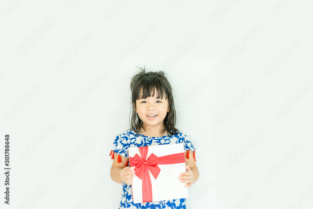 Little asian girl smile and holding red gift box on white background.child holding gift box.