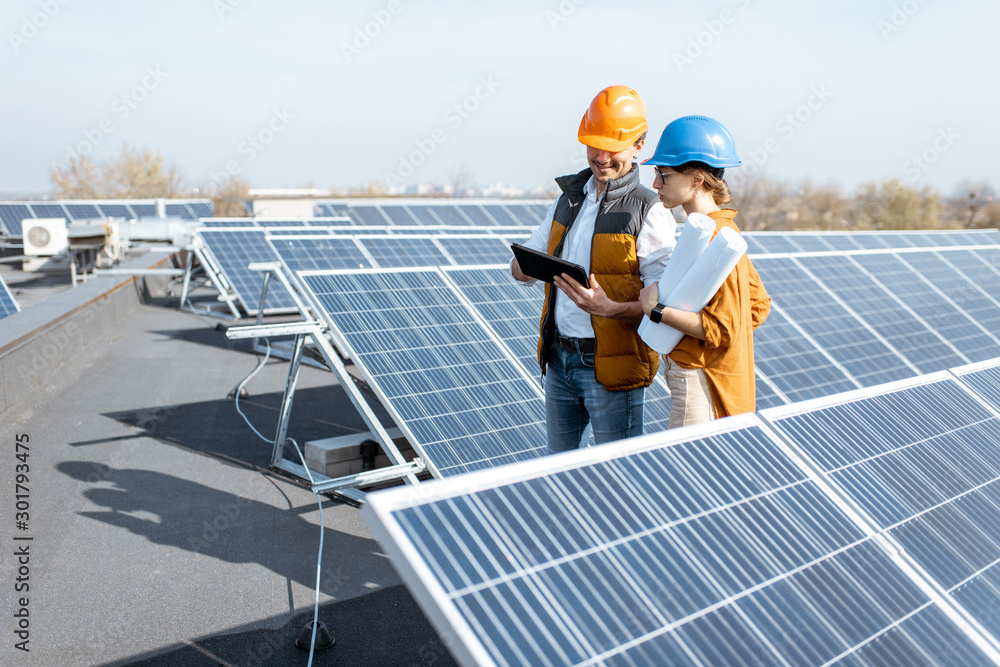 两名工程师或建筑师正在检查太阳能发电厂的建设，与数字同行