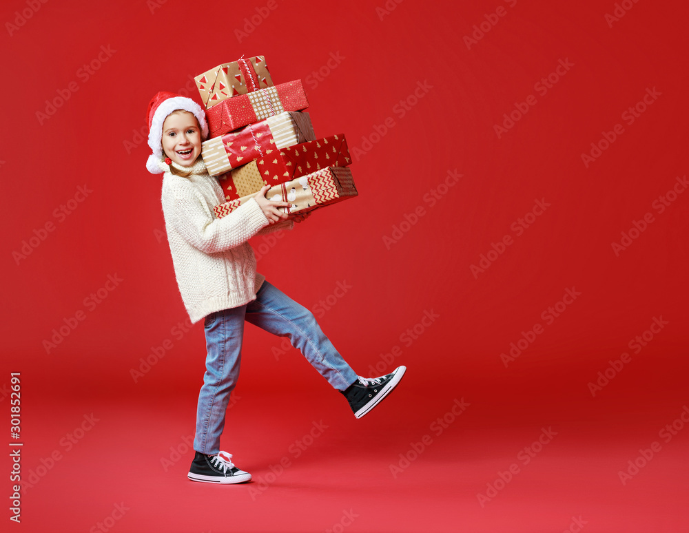 happy funny child girl    with Christmas gift on red   background