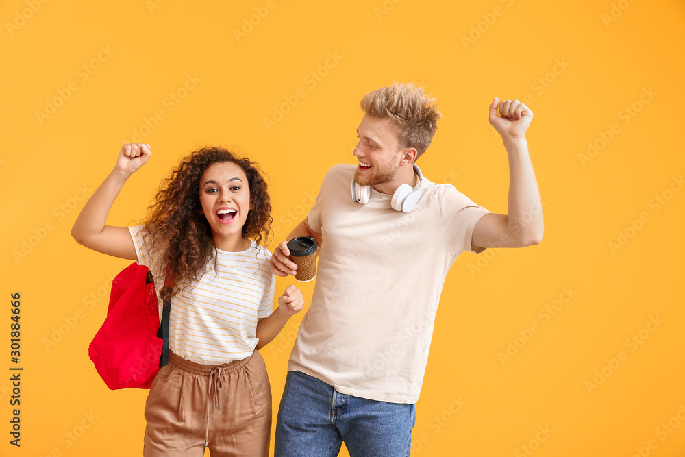 Portrait of happy female and male students on color background