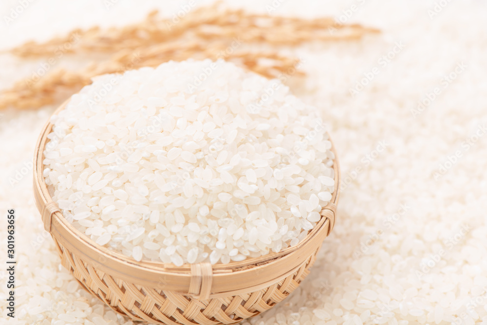 Raw white polished milled edible rice crop on white background in brown bowl, organic agriculture de