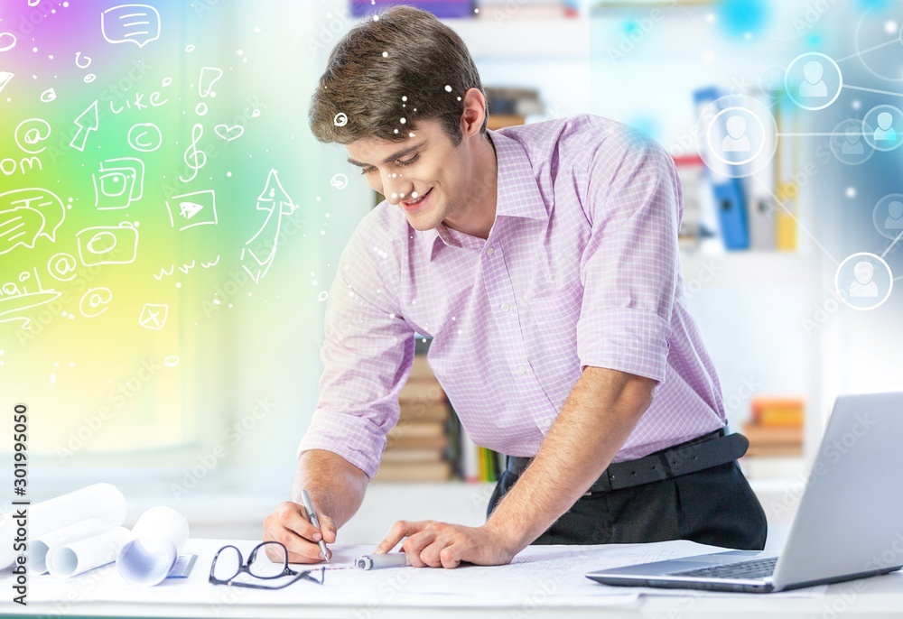 Young handsome man in glasses using laptop