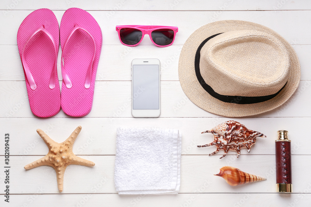 Composition with beach accessories on white wooden background