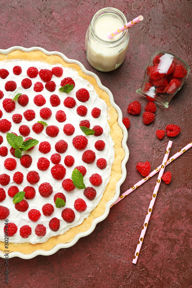 Tasty raspberry pie and bottle of milk on table