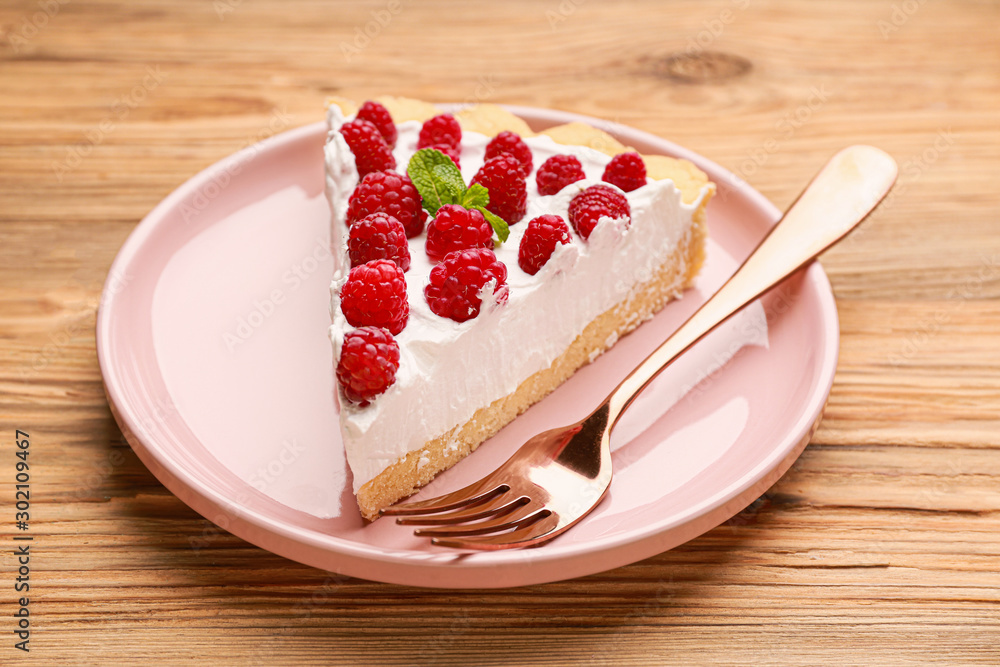 Plate with piece of tasty raspberry pie on table