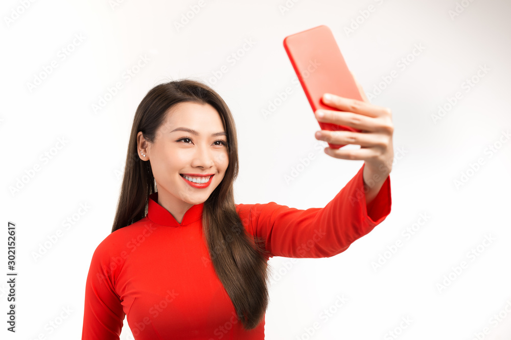 Asian Young Woman in red ao dai take the selfie