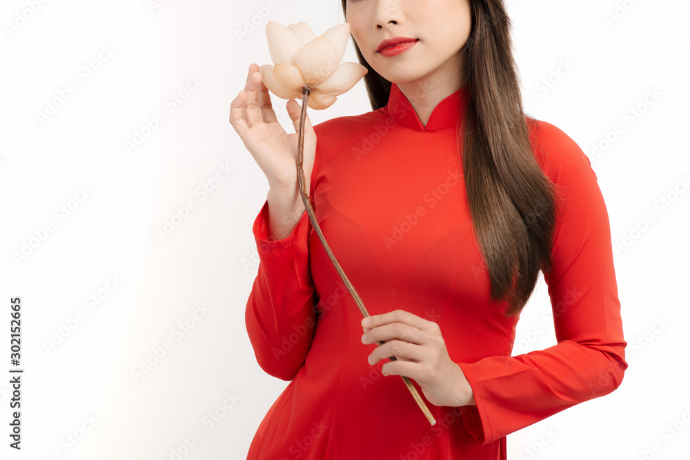 An Asian woman in Vietnamese dress admiring the lotus flower.