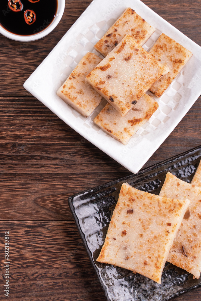 Delicious turnip cake, Chinese traditional radish cake in restaurant with soy sauce for new years d