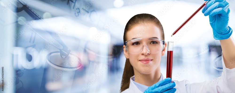 Young female scientist standing  on background