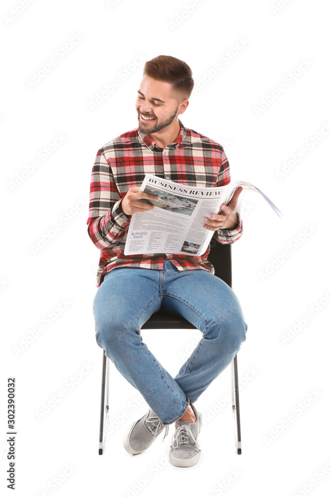 Handsome man with newspaper sitting on chair against white background