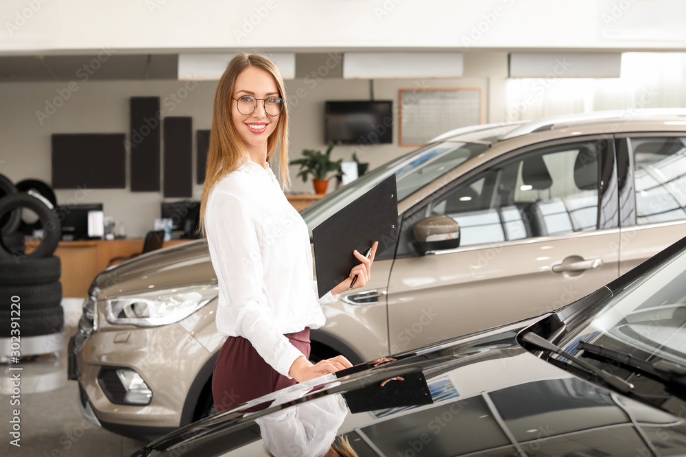 Saleswoman near car in modern salon